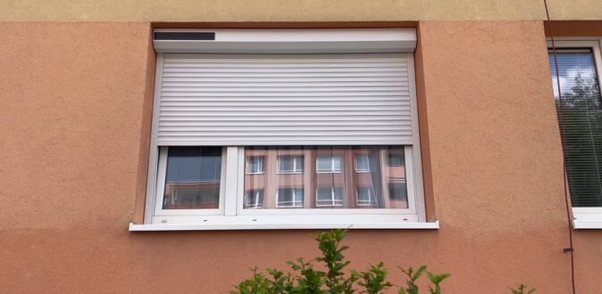 solární venkovní roleta na okně panelového domu v polostažené pozici